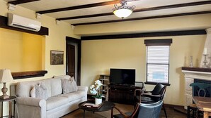 Una sala de estar con sofá, mesa de centro, televisor y chimenea.