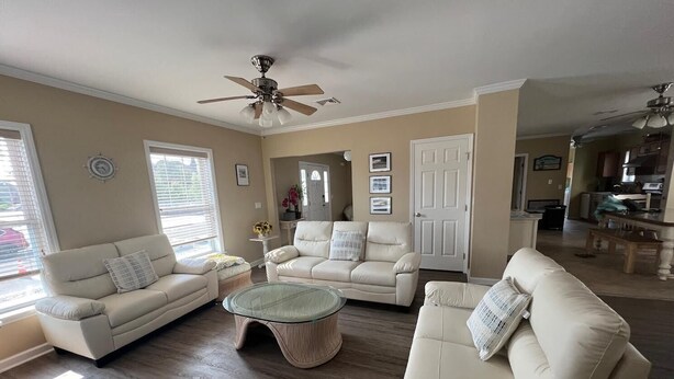 A spacious living room with a large window, a ceiling fan, and a dining area in the background. - 2 min walk to Jenkinson's Beach/Boardwalk. Beautiful, large house for big family (Point Pleasant Beach)