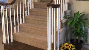 A staircase with dark wooden railings and beige carpeted steps. - 2 min walk to Jenkinson's Beach/Boardwalk. Beautiful, large house for big family (Point Pleasant Beach)