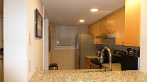A kitchen with granite countertops, stainless steel appliances, wooden cabinets, and a window with blinds. - Updated 2 BR/ 2.5 Bath Close to everything you need. (Hilton Head Island)