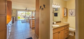 A spacious kitchen with a view to the outdoor patio, a wooden cabinet, and a tiled floor. - Incredible Ocean View,  Most Desirable Unit in the Complex (Kihei)
