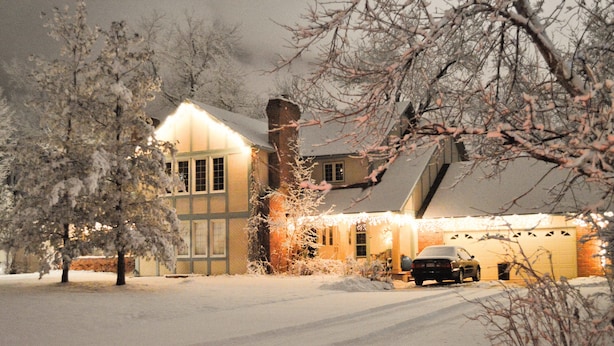 A snow-covered house with a garage and a car parked in front. - Gorgeous BROADMOOR English Tudor ~ Delightful Holiday Home, Hot Tub & Gazebo !! (Colorado Springs)