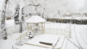 A gazebo with a snow-covered roof and steps, surrounded by snow-laden trees and a wooden fence. - Gorgeous BROADMOOR English Tudor ~ Delightful Holiday Home, Hot Tub & Gazebo !! (Colorado Springs)