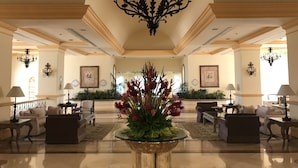 A spacious lobby with a central floral arrangement, elegant chandeliers, and comfortable seating areas. - Marina Villas - Grand Isla Navidad (Isla Navidad)