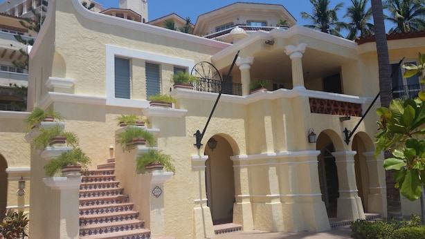 A multi-story building with a beige facade, a balcony with a wrought iron railing, and a staircase with patterned tiles. - Marina Villas - Grand Isla Navidad (Isla Navidad)