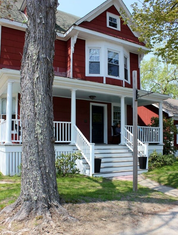 A two-story house with a porch, a large tree in front, and a well-maintained lawn. - Great for groups! Walking distance to Downtown Boothbay Harbor (Boothbay Harbor)