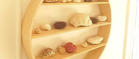 Une étagère circulaire en bois, dotée de plusieurs compartiments, chacun contenant divers objets décoratifs.
