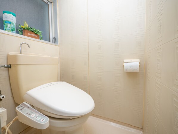 Une salle de bain moderne avec des toilettes, un lavabo et une fenêtre.