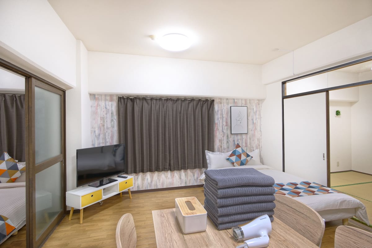 A hotel room with a bed, a TV, a desk, and a bathroom.