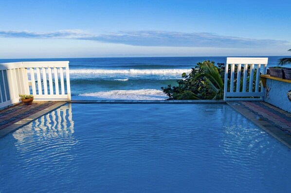 Guests can enjoy a serene infinity pool overlooking the ocean.
