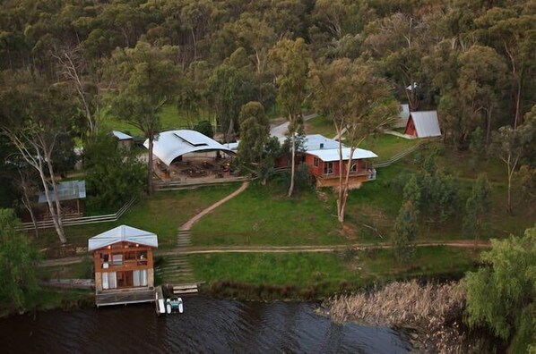 A lakeside property with multiple cabins, a dock, and a forested area. - Fawlty Farm in Taylor Bay with 3 FREE experiences (Taylor Bay)
