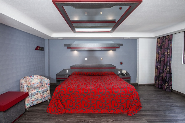 Une chambre à coucher moderne avec un lit, une chaise et un mur d’accent de couleur rouge.