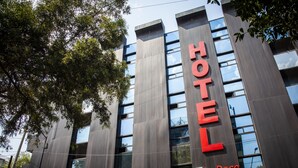 A modern hotel building with a prominent "HOTEL" sign and "La Rosa" branding.