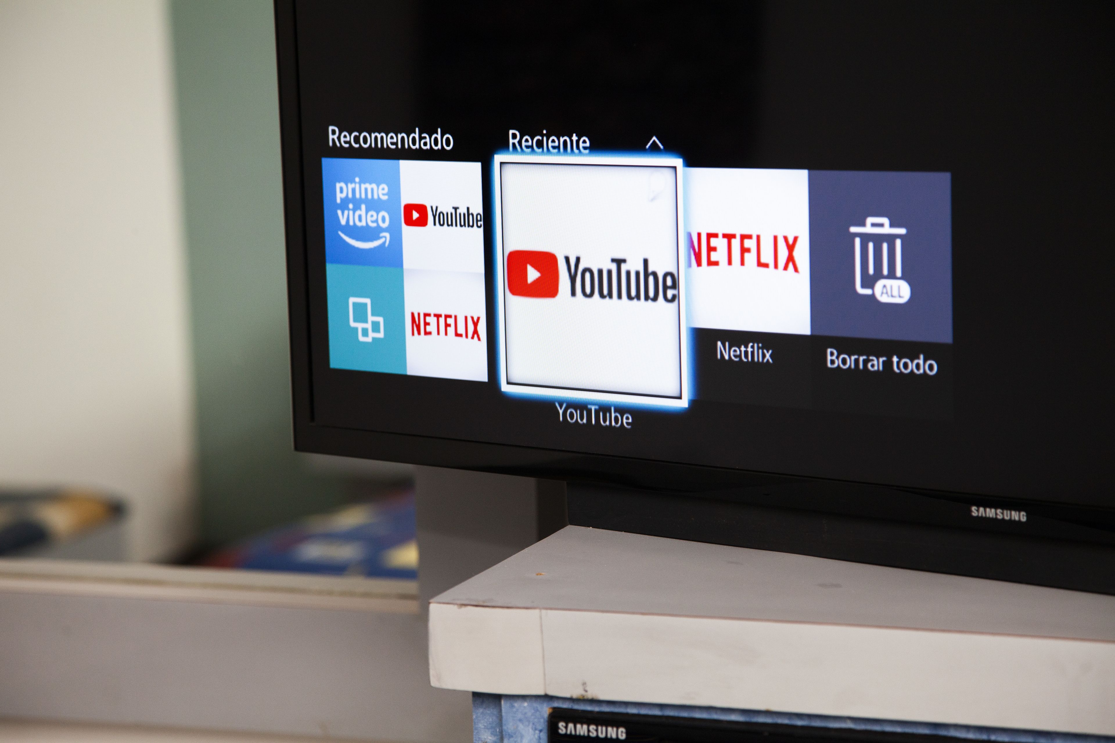 A television screen displaying a media streaming interface with app icons for Prime Video, YouTube, Netflix, and a trash bin icon.