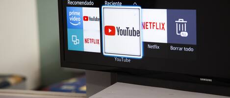 Una pantalla de televisión que muestra una interfaz de transmisión de medios con iconos de aplicaciones para Prime Video, YouTube, Netflix y un icono de papelera.