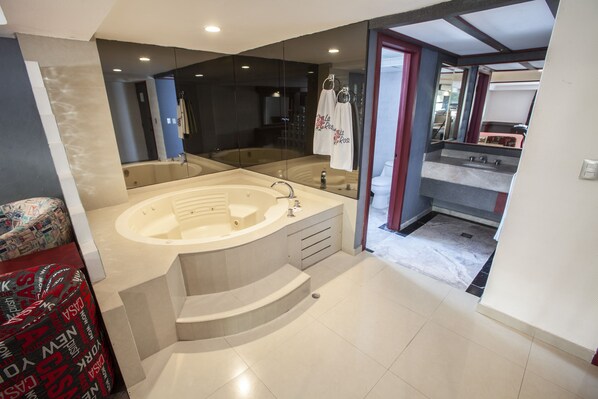 A modern bathroom with a large bathtub, a separate shower area, and a vanity with a sink.