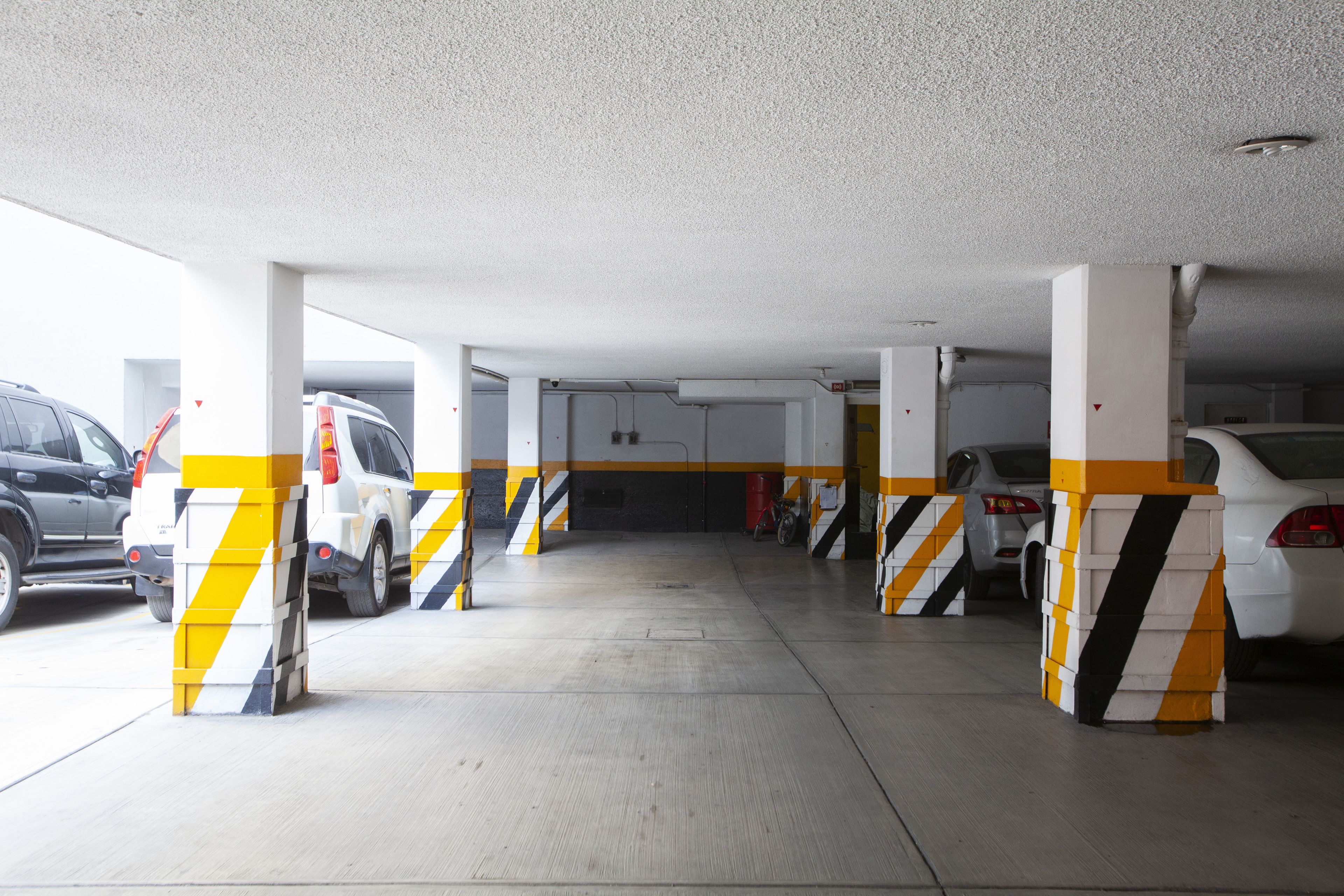 A parking garage with multiple levels and yellow and black striped columns.