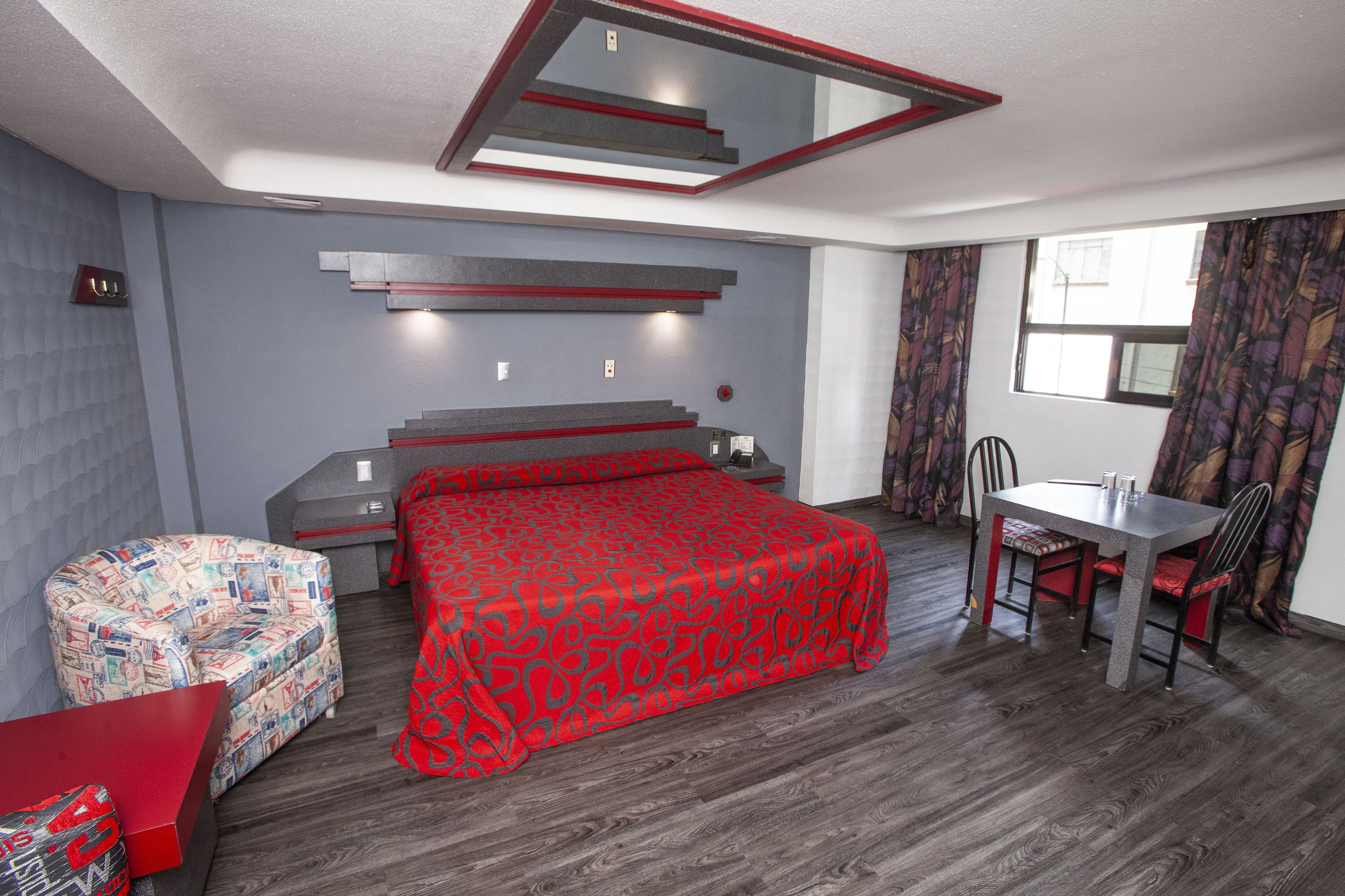 Une chambre d’hôtel moderne, dotée d’un grand lit, d’un bureau et d’une chaise.