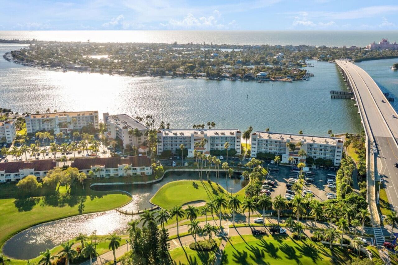 A coastal hotel with multiple buildings, a marina, and a bridge.