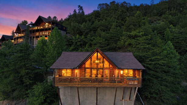 A multi-story lodge with a balcony, surrounded by dense forest. - 🏔️Private Sunsets🌅 Sunset Views, Hot Tub & Indoor Pool, near Dollywood (Sevierville)