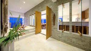 Un interno moderno con una parete in pietra, porte in legno e vista sulla città.