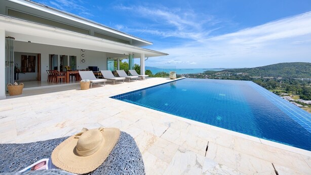 Una villa moderna con piscina a sfioro privata e vista su un paesaggio suggestivo.