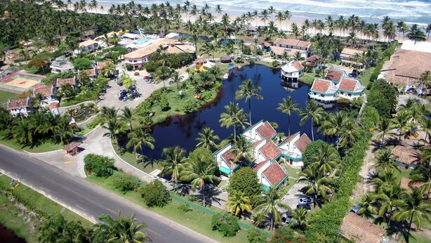 An aerial view of a coastal resort with a central water feature, surrounded by palm trees and beach access. - BLACK FRIDAY FEBRUARY. Beautiful duplex house, Ilhéus-Bahia, Olivença, Cond.  (Ilheus)