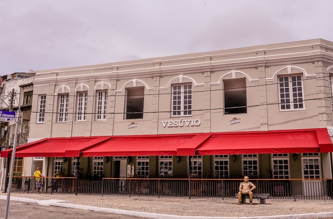 A building with a red awning and the name "VESÚVIO" on the facade.