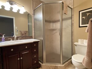 A bathroom with a glass-enclosed shower, a vanity with a mirror, and a toilet. - Mountain Harbor #205 3 Bedroom Condo (Whitefish)