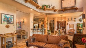 Un vaste espace de vie comprenant un canapé marron à motifs, des meubles en bois et une table à manger.