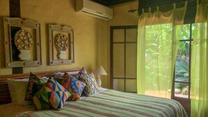 A bedroom with a bed, pillows, a nightstand, a lamp, and a window with curtains. - House 50m from the beach in a unique gated community, total privacy, Camburizinho.  (Sertão do Cambury)