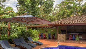 A pool area with lounge chairs, a covered seating area, and a bar. - House 50m from the beach in a unique gated community, total privacy, Camburizinho.  (Sertão do Cambury)