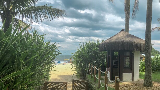 A beach entrance with a thatched hut, a stone pathway, and a view of the beach and ocean. - House 50m from the beach in a unique gated community, total privacy, Camburizinho.  (Sertão do Cambury)