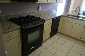 Enjoy cooking in this well-equipped kitchen with a stove, dishwasher, and ample cabinetry.