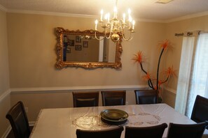 Dine in style with a classic dining room featuring a large mirror, elegant table, and comfortable seating.