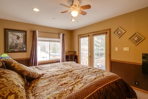 A bedroom with a large bed, a ceiling fan, and a window with curtains. - Empire Vacation Rental w/ Fire Pit & Gas Grill! (Empire)