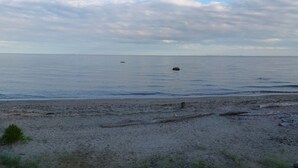 Una playa con arena, mar tranquilo y cielo parcialmente nublado.
