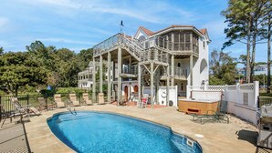 A large house with a swimming pool, a hot tub, and a deck with chairs. - Sound's Great! | Sound Front | Private Pool | Corolla (Corolla)