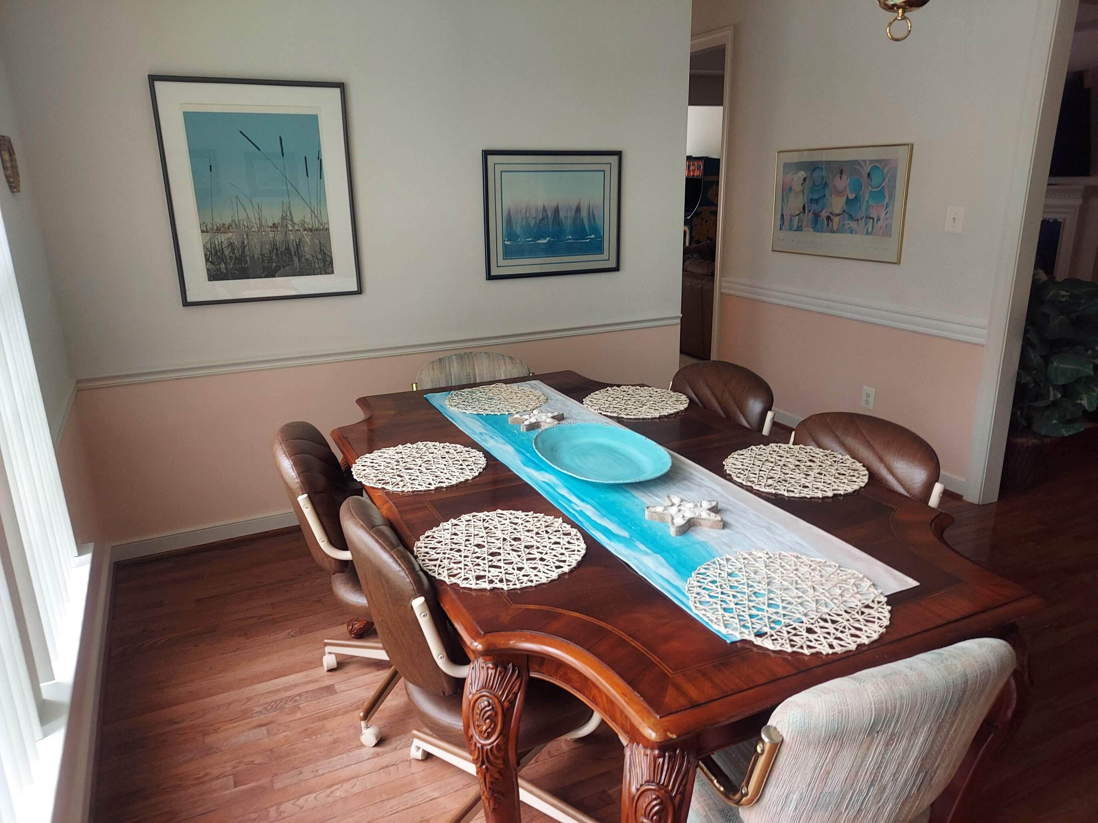 Ein Esszimmer mit Holztisch, Ledersesseln und dekorativen Tischsets.