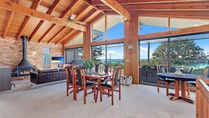 A spacious kitchen with a brick wall, a large window, and a fireplace. - Beachcombers on Collingwood Beach (Vincentia)