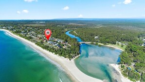 An aerial view of a coastal area with a beach, a river, and a forested area. - Beachcombers on Collingwood Beach (Vincentia)