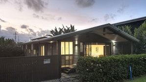 Une maison moderne dotée d’un porche abrité, d’une allée en gravier et d’une pelouse bien entretenue.
