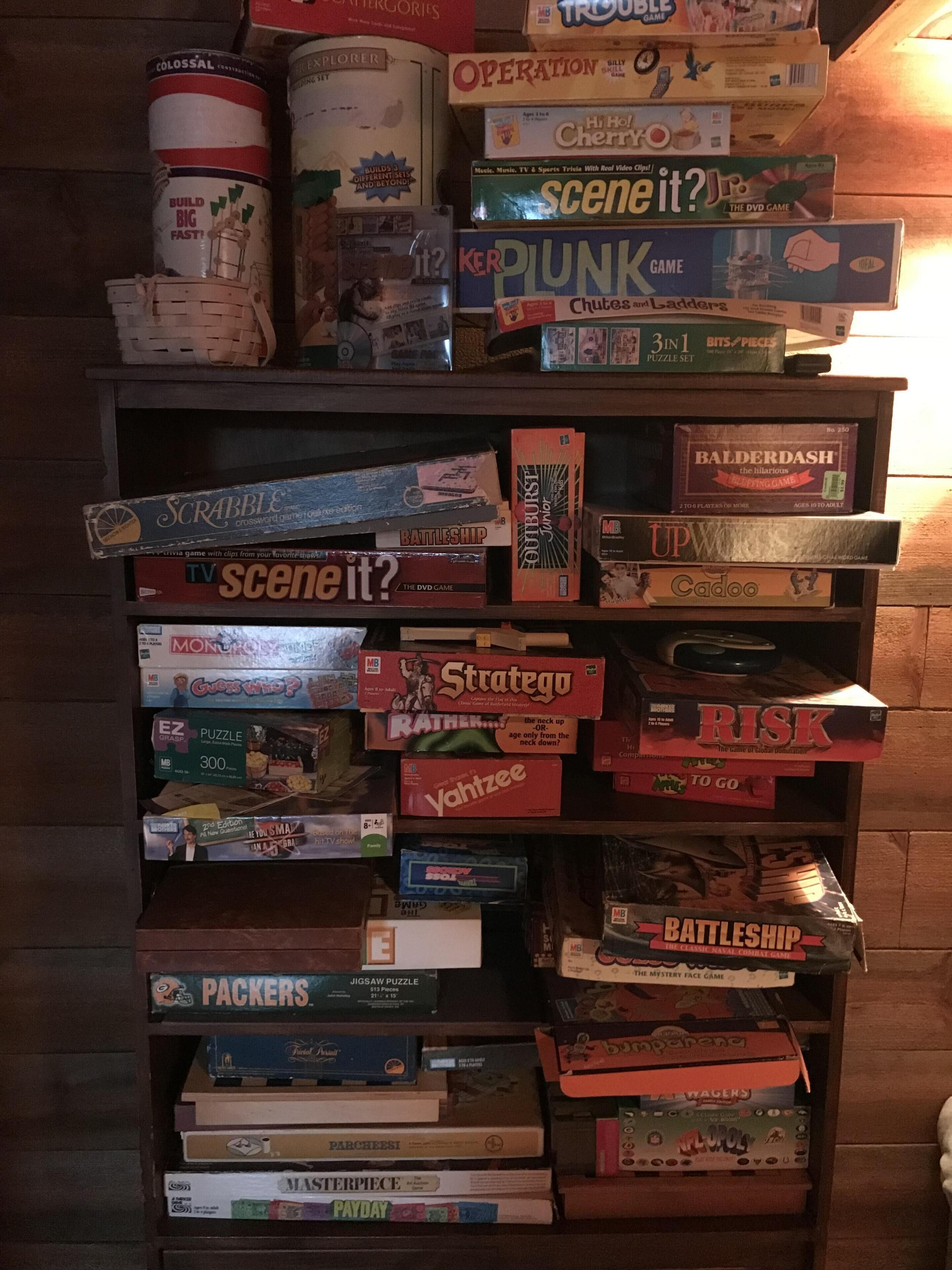 Une étagère sur laquelle sont empilés différents jeux de société.