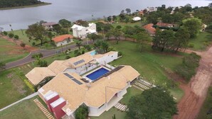 A large house with a swimming pool, surrounded by a lush green landscape and a body of water. - Dream, Dam, heated pool, 4 suites. Coffee shop, Restaurant, Burger joint.<br><br> <br><br><br><br><br><br><br><br><br> (Paranapanema)