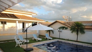 A swimming pool with lounge chairs and a white umbrella, surrounded by a well-maintained lawn and a building with a tiled roof. - Dream, Dam, heated pool, 4 suites. Coffee shop, Restaurant, Burger joint.<br><br> <br><br><br><br><br><br><br><br><br> (Paranapanema)