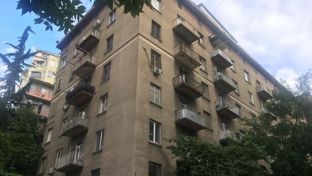 Un immeuble à plusieurs étages doté de balcons, de fenêtres et de climatiseurs.
