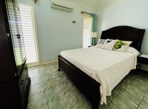 Une chambre à coucher avec un lit, une table de chevet, une lampe et une commode.