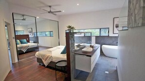 Un dormitorio moderno con cama, mesita de noche y un espejo grande.