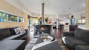 Una sala de estar moderna con chimenea, sofás y comedor.