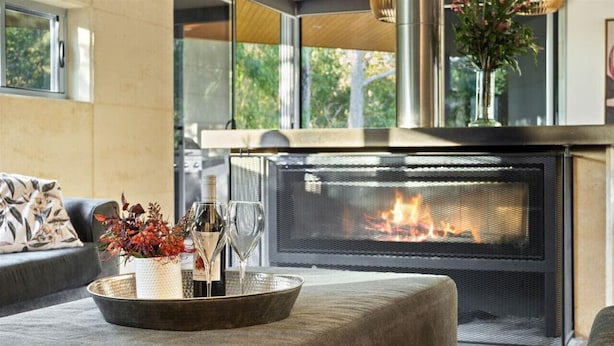 Una sala de estar moderna con chimenea, un sofá y una bandeja decorativa con flores.